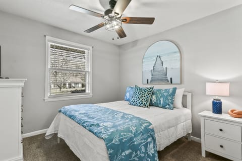 The third bedroom features a queen bed, a TV, and calming blue accents, creating a serene and cozy retreat.