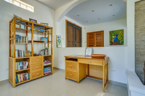 Office desk and bookshelf with books and games