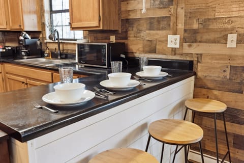 Enjoy the convenience of dining and socializing at our trendy bar counter with three rustic stools.