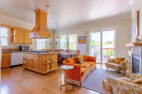 Warm, open living area with elegant chandelier and deck view