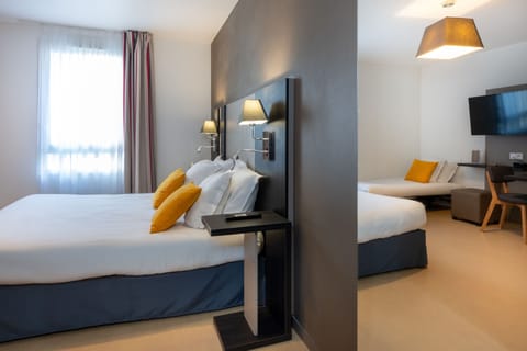 The modern Junior Suite boasts a stylish design featuring a cozy double bed adorned with vibrant yellow cushions.