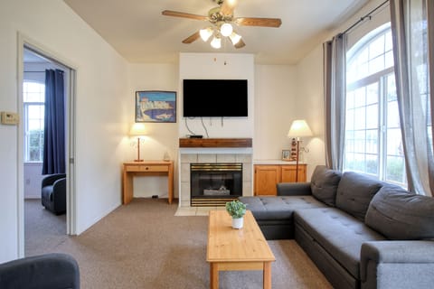 This cozy downstairs unit features a sectional couch, study space, a fireplace, and plenty of natural light.