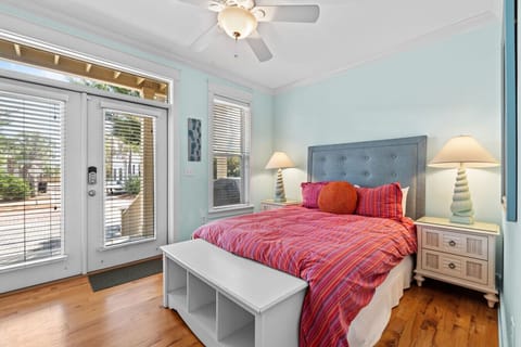 Wake up to natural light and step out onto the porch from this serene bedroom with a plush bed and coastal decor.