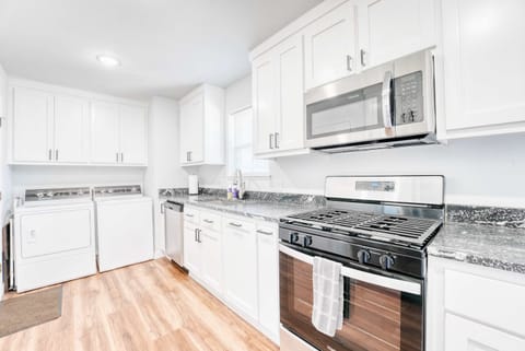 Open kitchen boasts a gas range, microwave and adjacent laundry area—everything you need in one space.