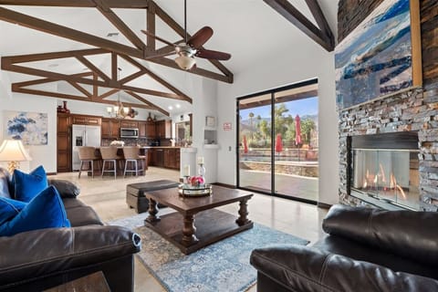 Well lit living area, fireplace, high ceiling with stylish wooden beams