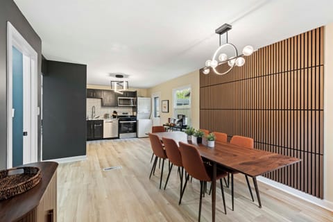 🍽️ Cook, Dine & Connect in Style Enjoy meals and memories in this sleek open-concept kitchen and dining area, featuring modern appliances, a bold accent wall, and seating for eight—perfect for family dinners or group getaways.