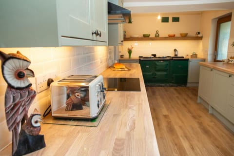 Kitchen with plenty of work tops, breakfast bar, stools and wall mounted TV