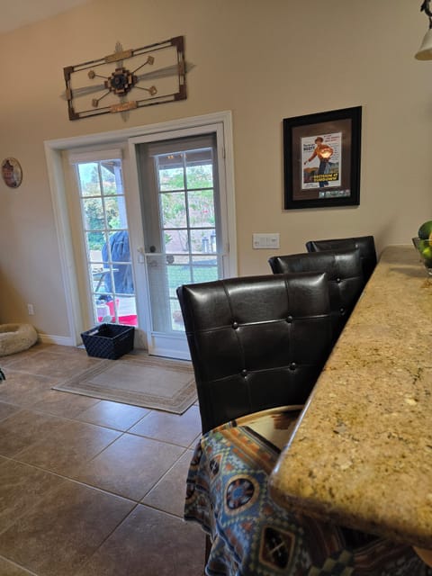 Kitchen bar with 3 comfy high chairs. Exit to the back patio.