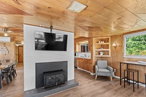 Comfortable living area featuring a TV, cozy chair, and a warm fireplace.