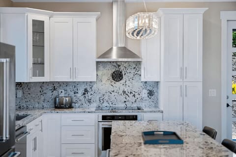 Designed for both everyday meals and special gatherings, this kitchen features a breakfast bar, under-cabinet lighting, and modern fixtures.
