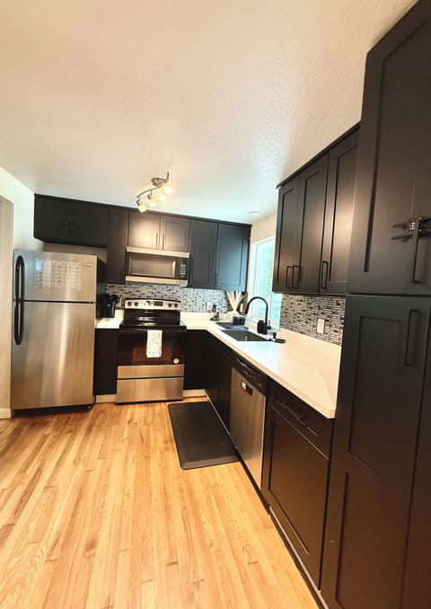 The modern kitchen is equipped with stainless steel appliances, sleek cabinetry.