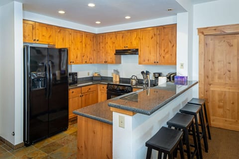 The fully equipped kitchen features a breakfast bar with barstool seating | Main Level