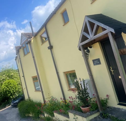 Front view of the house, with parking space visible to side.