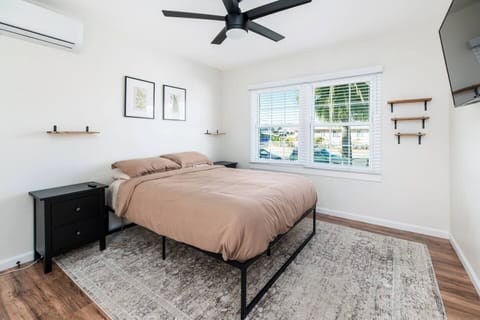 Minimalist bedroom featuring a queen bed, cozy comforts & stylish decor