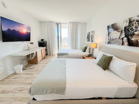 Spacious bedroom with balcony access and Smart TV.