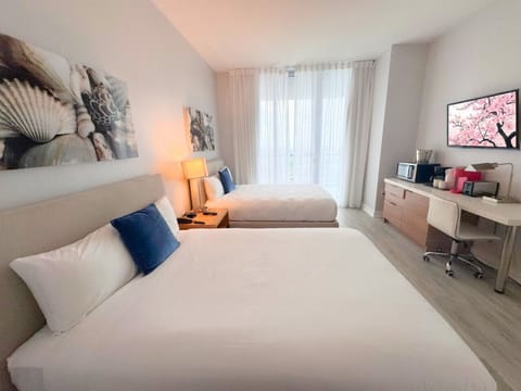 Spacious bedroom with balcony access and Smart TV.