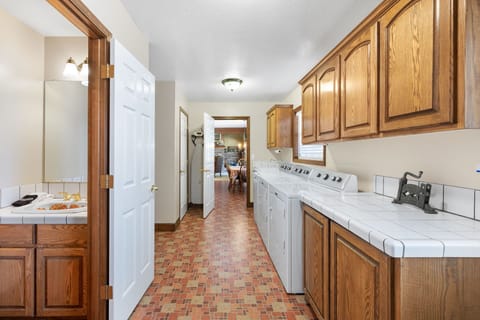 Laundry room w/a peek into the 1/2 bath & kitchen. Laundry & cleaning supplies.
