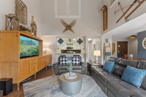 The living room features a wood burning fireplace, large smartTV, ample seating, and access to the private balcony.