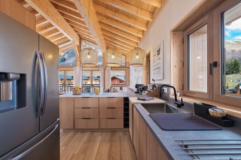 Fully equipped open kitchen, modern design with friendly bar and exterior view.