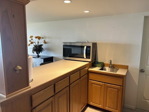 Kitchen has typical items for cooking, heating foods or making dishes.