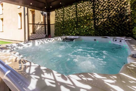 Serene hot tub retreat with lush green surroundings, perfect for relaxation tonight!
