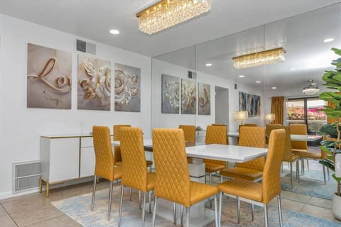 Enjoy meals around a beautiful 8-seat table beneath a stunning chandelier. Surrounded by elegant decor and a vibrant LOVE painting.