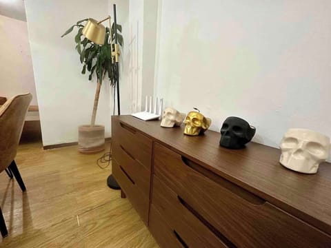 Sala de estar (cómoda con decoración, planta de decoración y lámpara)