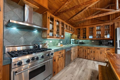 Cook like a pro in the fully equipped kitchen at Sunrise Lodge, featuring a Viking stove, dishwasher, KitchenAid mixer, and charming rustic cabinetry. Perfect for preparing meals with family or friends during your Lake Travis getaway.