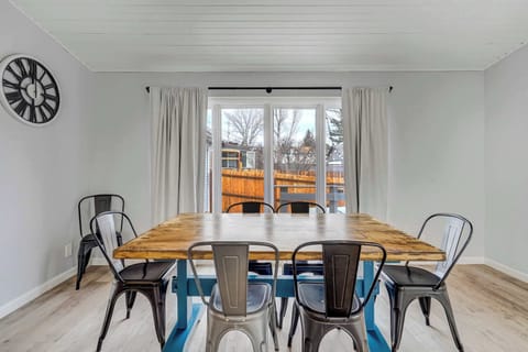 Bright and airy dining area with a large farmhouse-style table, plenty of seating, and direct access to the outdoor deck—perfect for shared meals and lively conversations.