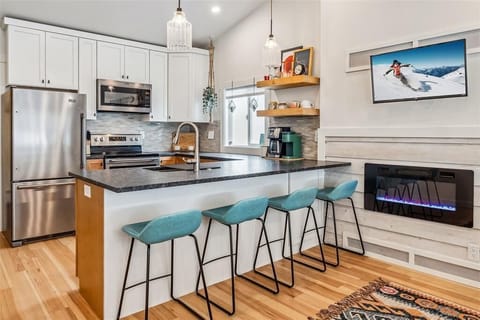 Enjoy the ambiance of the electric fireplace and smart TV mounted in the wall in the dining area, perfect for watching some high alpine cooking inspiration!