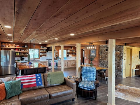 Living space adjacent to open area dining table, kitchen and island