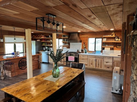 Dining table adjacent to open-area kitchen and island