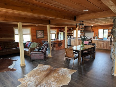 Living space adjacent to open area dining table, kitchen and island