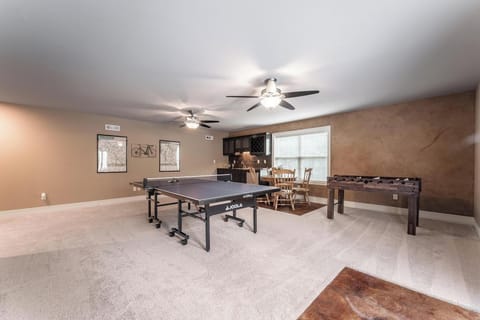 Ping pong, foosball and family game table, plus large TV and wet bar game room