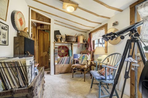 This cozy nook blends whimsy and warmth with exposed beams, a reading chair, telescope, and a record player with vintage vinyls—perfect for quiet nights spent stargazing, flipping through a book, or enjoying old tunes.