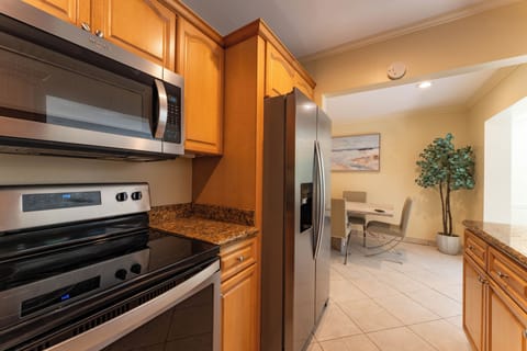 Fully stocked kitchen with granite counters and stainless steel appliances.