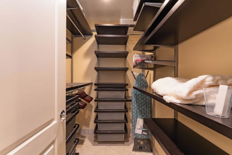 Primary suite with luxe throws, workspace, and organized closet storage.