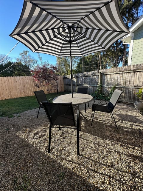 Private fenced backyard with patio seating and fire pit.