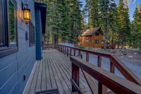 Exterior: Main entry deck with railing, forest view, and on-site driveway parking
