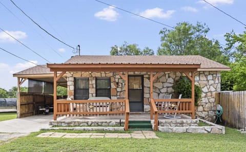 A cozy stone vacation rental with a charming front porch, perfect for a relaxing getaway.