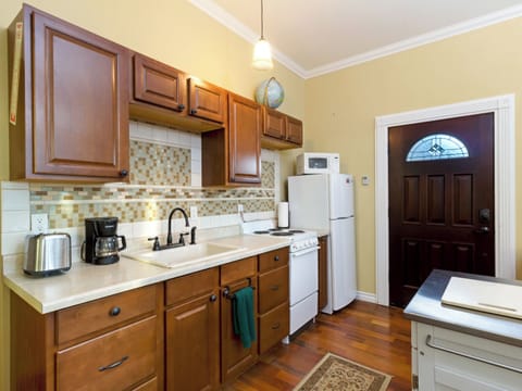 Kitchen area attached to the living space, has a Keurig coffee maker, microwave, refrigerator, and basic cookware, dishes and utensils.