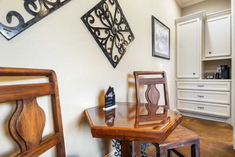 Enjoy a cozy meal or coffee break at this charming dining nook, complete with elegant wall decor and convenient built-in cabinetry for all your needs.