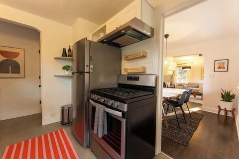 Sleek kitchen with stainless steel appliances and open sight lines to dining and living areas.