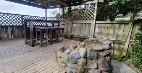 PERGOLA AT THE FRONT OF THE PROPERTY WITH A BAR TABLE, FIREPIT & OUTDOOR SHOWER