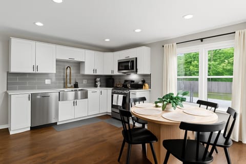 Modern, fully stocked kitchen with stainless steel appliances and a cozy dining space overlooking the backyard.