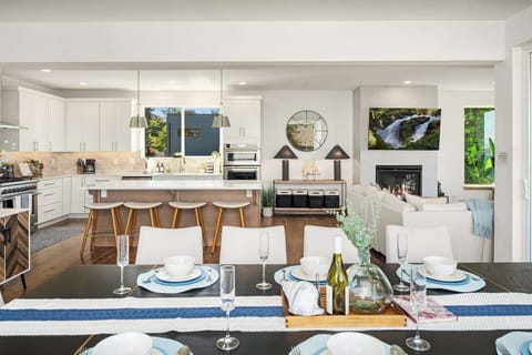 Fireplace lounge + dining area + gourmet kitchen, all under an open vaulted ceiling.