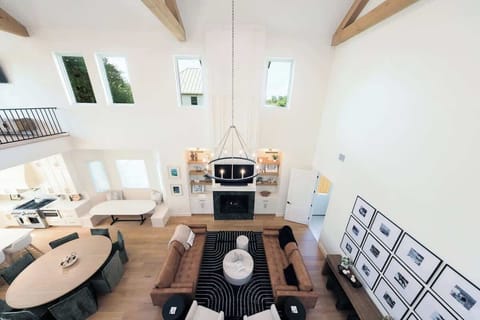 Soaring ceilings, stunning design ✨ This open-concept living space blends comfort and elegance with natural light, exposed beams, a cozy fireplace, and room for everyone to gather in style.