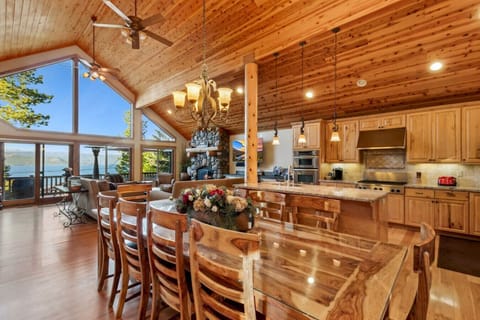 Spacious and open great room with dramatic vaulted ceilings, big views of the lake, river rock gas fireplace and large flat screen SmartTV