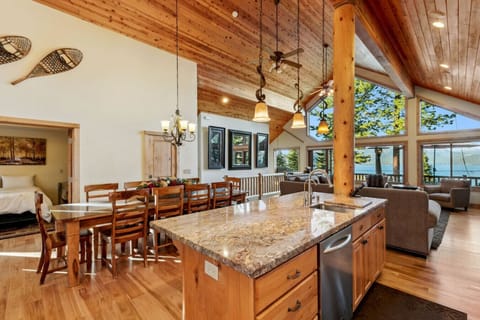 Spacious and open great room with dramatic vaulted ceilings, big views of the lake, river rock gas fireplace and large flat screen SmartTV