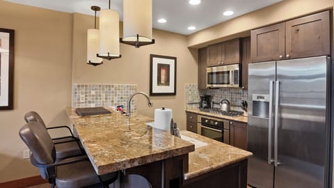 Spacious kitchen with granite counters and storage.